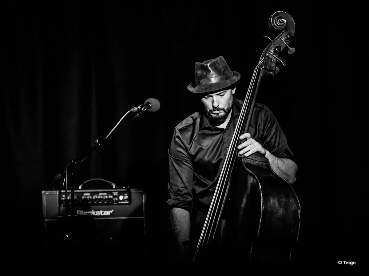 Portrettfoto av Steinar Raknes med kontrabass, mikrofon og forsterker