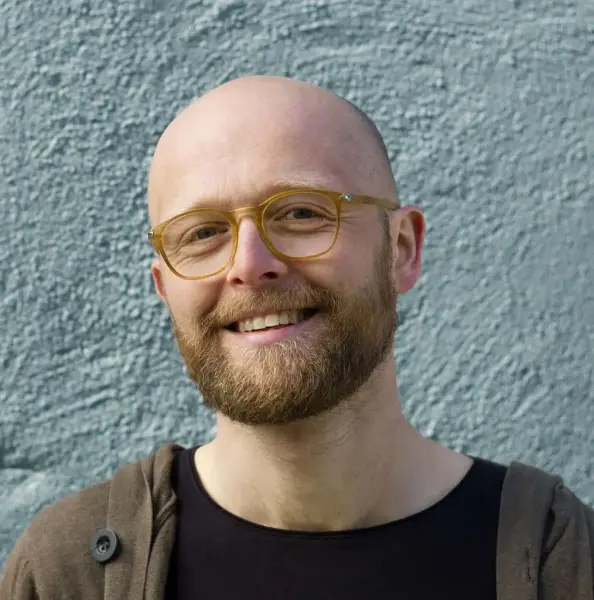 Profilbilde av Vegard Markhus framom ein vegg med murpuss