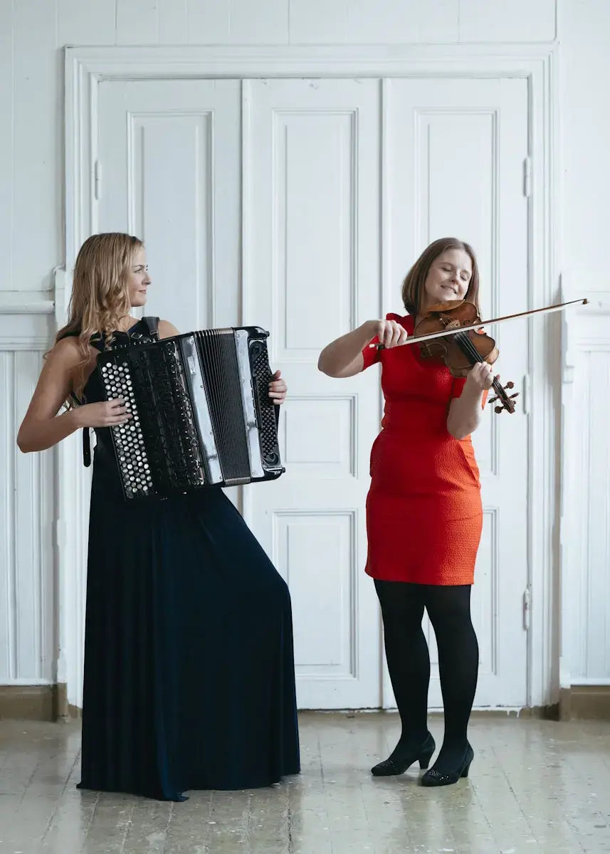 Kristina Bjørdal Farsta med svart kjole og trekkspel og Jorun Marie Kvernberg med raud kjole og fele