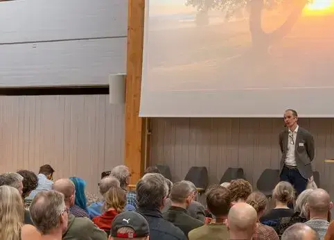 Mann holder foredrag fra en scene 