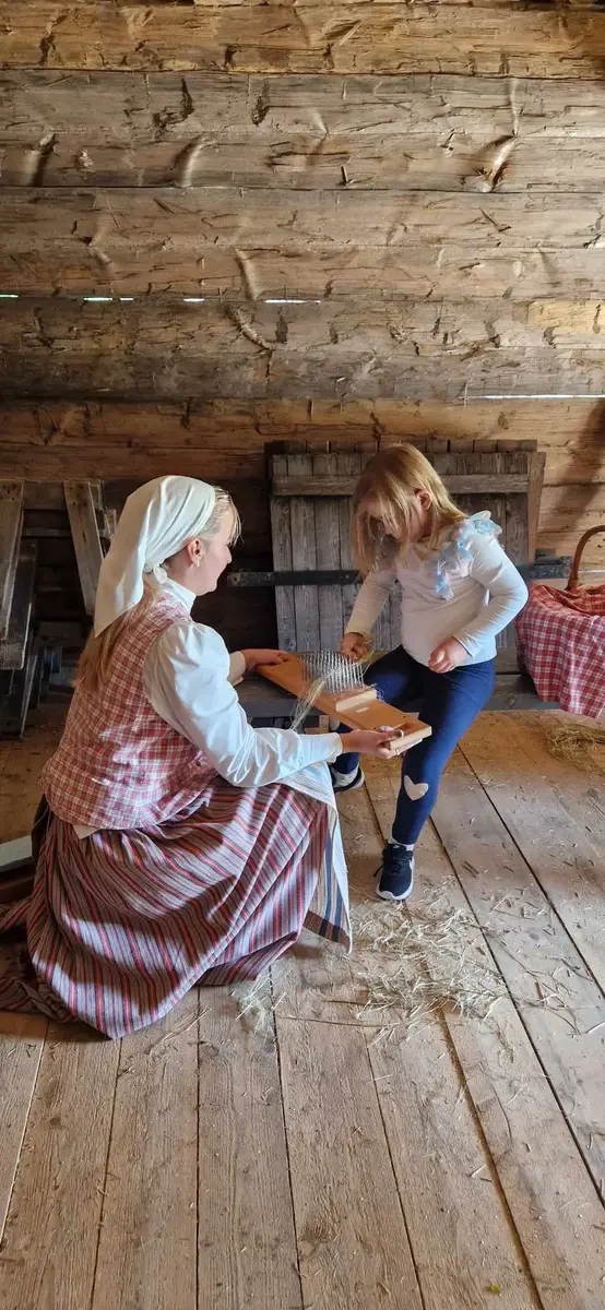 Barn häcklar lin med handledning av vuxen