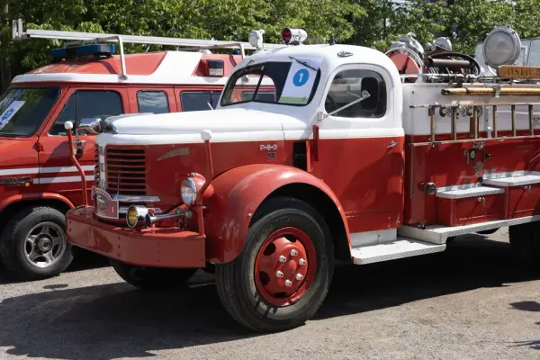 To røde brannbiler, en med stigeløfter og en uten, utstilt på Norsk Folkemuseum under brannbilhelgen.