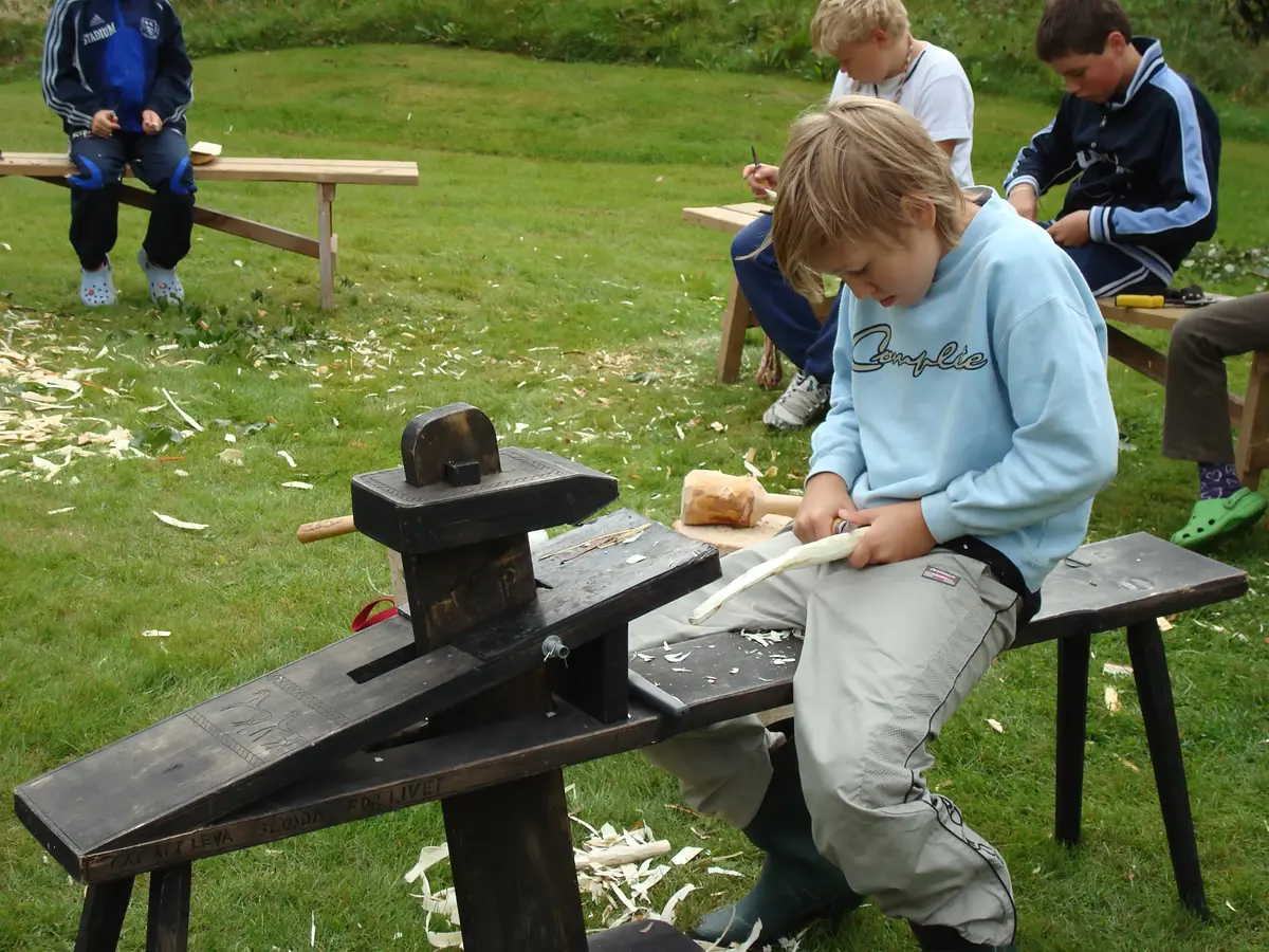 Pojke täljer sittandes på en täljhäst
