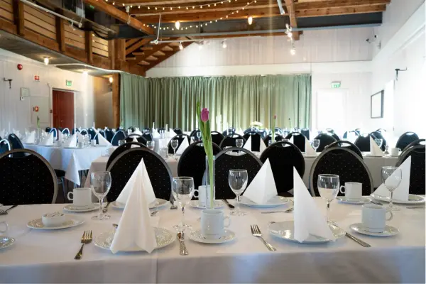 Dekkede bord i storsalen på låven