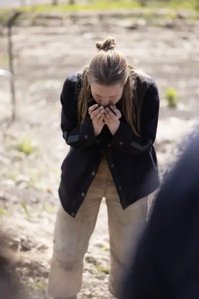 Gartner lukter på en neve jord under omvisning og lynkurs i økologisk dyrking på Bygdø Kongsgård.