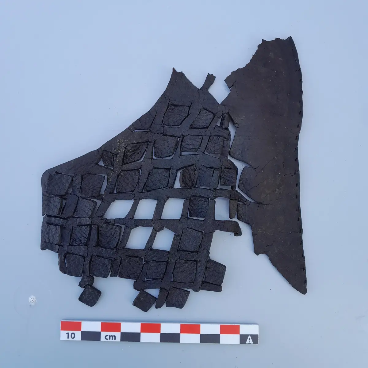 Dekorert overlær fra middelaldersko med rutemønster funnet ved Bjørvika skole.