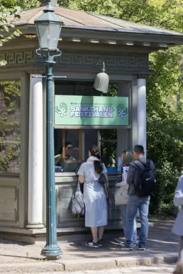 Visitors buying tickets at the entrance booth for the Midsummer Festival at Norsk Folkemuseum.