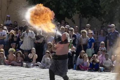 Artist fra Stella Polaris blåser ild foran publikum under Sankthansfestivalen på Norsk Folkemuseum.