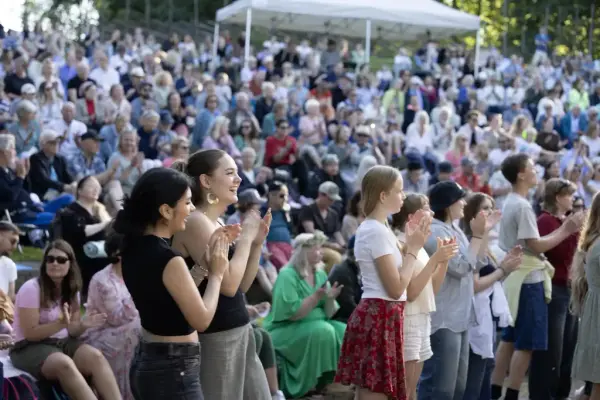 Publikum klapper og koser seg under en konsert på Sankthansfestivalen på Norsk Folkemuseum.