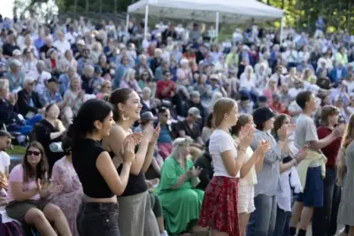 Publikum klapper og koser seg under en konsert på Sankthansfestivalen på Norsk Folkemuseum.