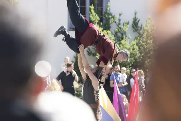 Two performers from Stella Polaris executing an acrobatic lift in front of an audience at the Midsummer Festival at Norsk Folkemuseum.