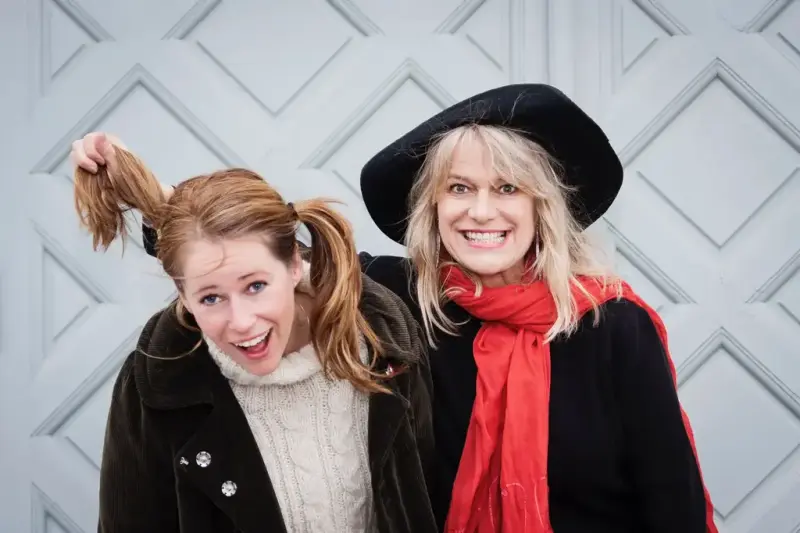 To kvinner holde rundt hverandre og lager tøysete grimaser. 