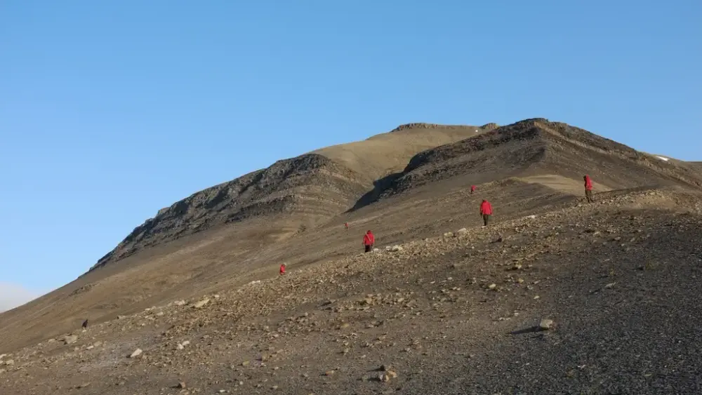 En gruppe mennesker på vei opp et fjell på jakt etter fossiler.