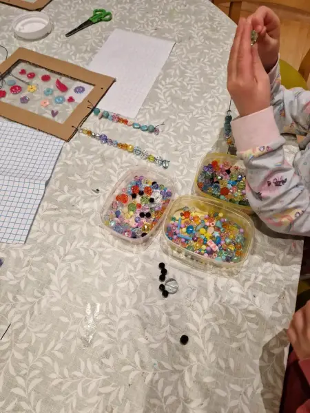 Ett barn som sitter och pärlar till en solfångare. 