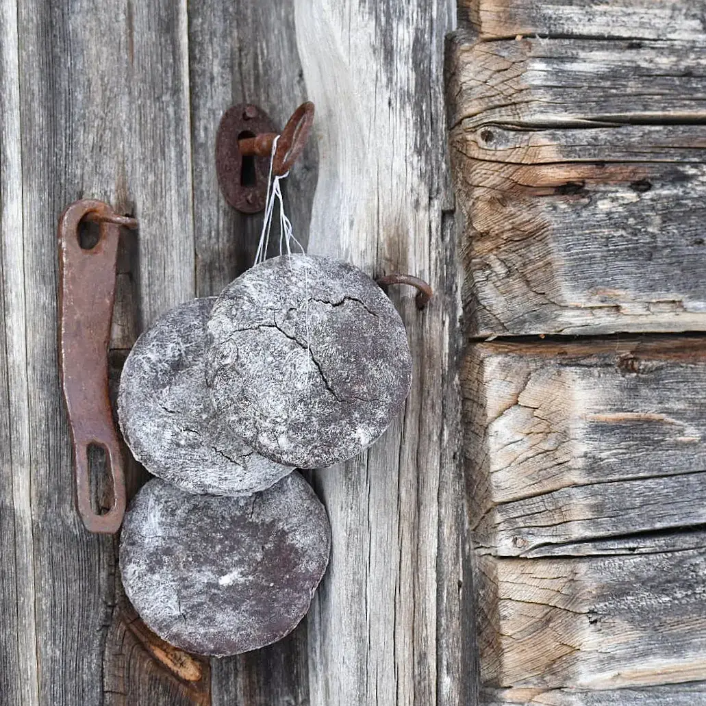 runde brød henger til tørk på snor på døra til et gammelt stabbur