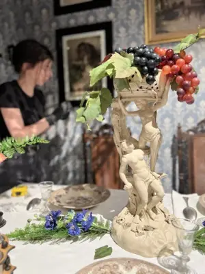 En närbild på ett dukat bord. På bordet står antika föremål