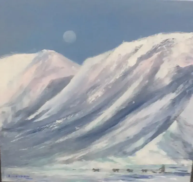 Vinterlandskap med høye fjell og blå himmel med måne. Ved foten av fjellene kjører en person med hundespann.