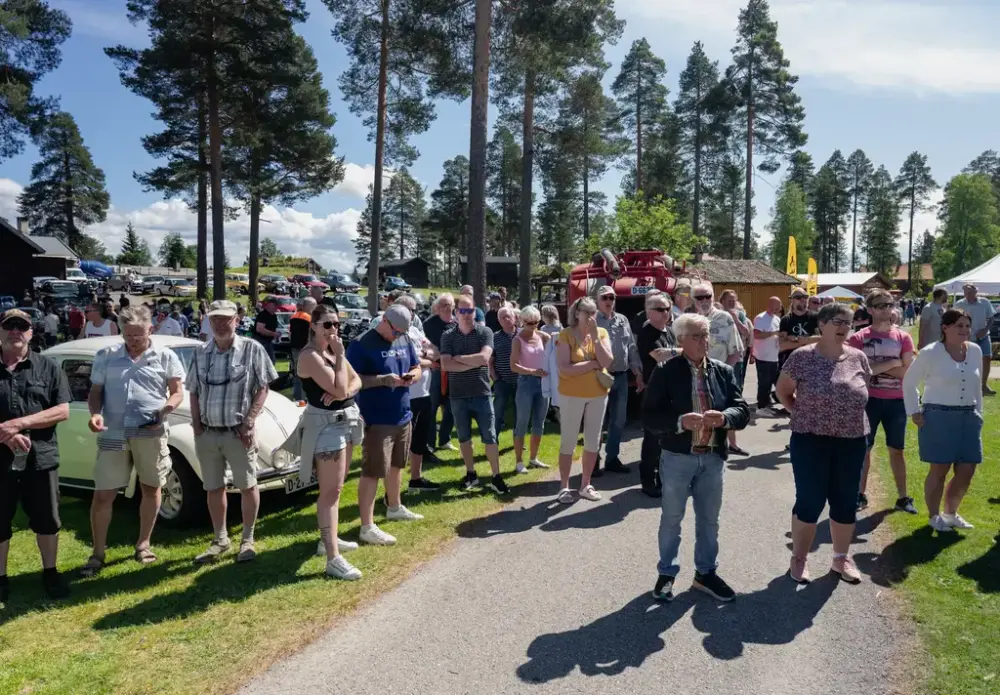 Publikum følger spent med under bilutstilling på Veterandag ved Glomdalsmuseet i Elverum, omgitt av furutrær og sommervær