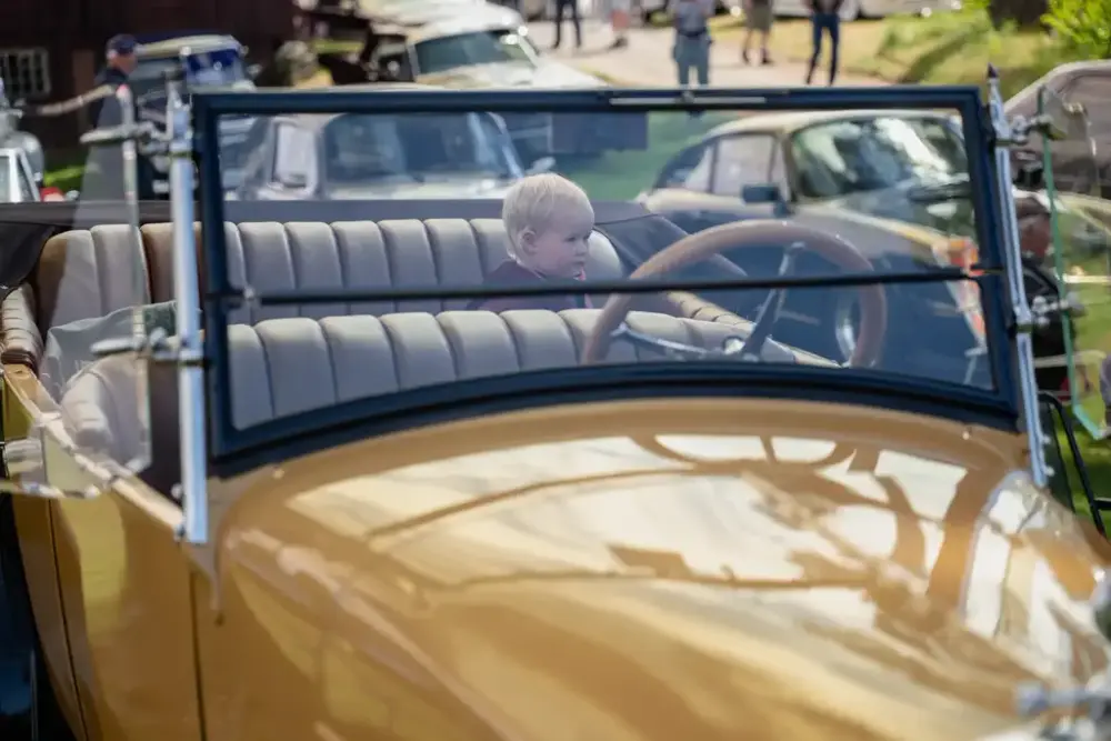 Veteranbil med et lite barn i baksetet
