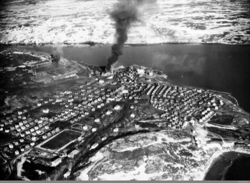 Kirkenes og A/S Sydvaranger under bombing. Vi ser røyk fra brennende hus