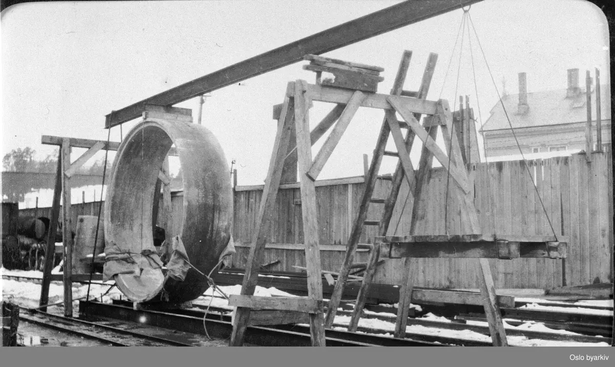 Opphenging av prefabrikert kloakkrør i betong (2,4 meter i diameter!). Festningsmur i bakgrunnen. Fra 1920-tallet.