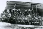 Arbetare vid Ekensbergs varv fotograferade mot ett skrov av trä ZULEIKA.
Summa 78 personer.
Brigantinen ZULEIKA av Liverpool (HVFB) var byggd 1866 på P E Island och förliste (wrecked) i oktober 1889.
Kopia skänkt av C Jansson, Hammarby, till Roslagens sjöfartsmuseum.
(Fadern med på bilden.)