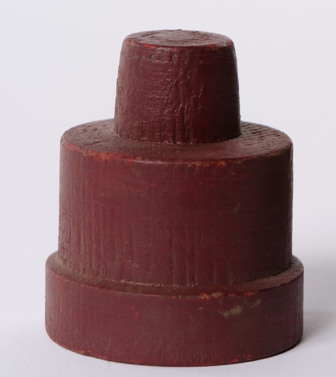 Sirkulær form av tre i tre etasjer, rødmalt.