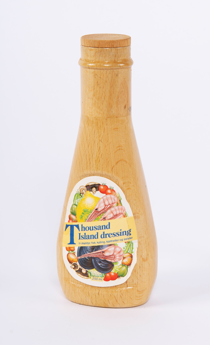 Flaskemodell i tre. Påklistret lapp på den ene siden.