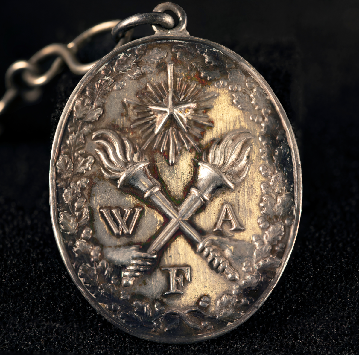 Lommeur med kjede av fire lenker og fem kjeder med anheng. Kjede med signet W, en oval medaljong med to kryssede fakler (WFA), en tannpirker formet som nøkkel, en mynt (F III 1666), firkantet uropptrekker. Stempel: se foto.