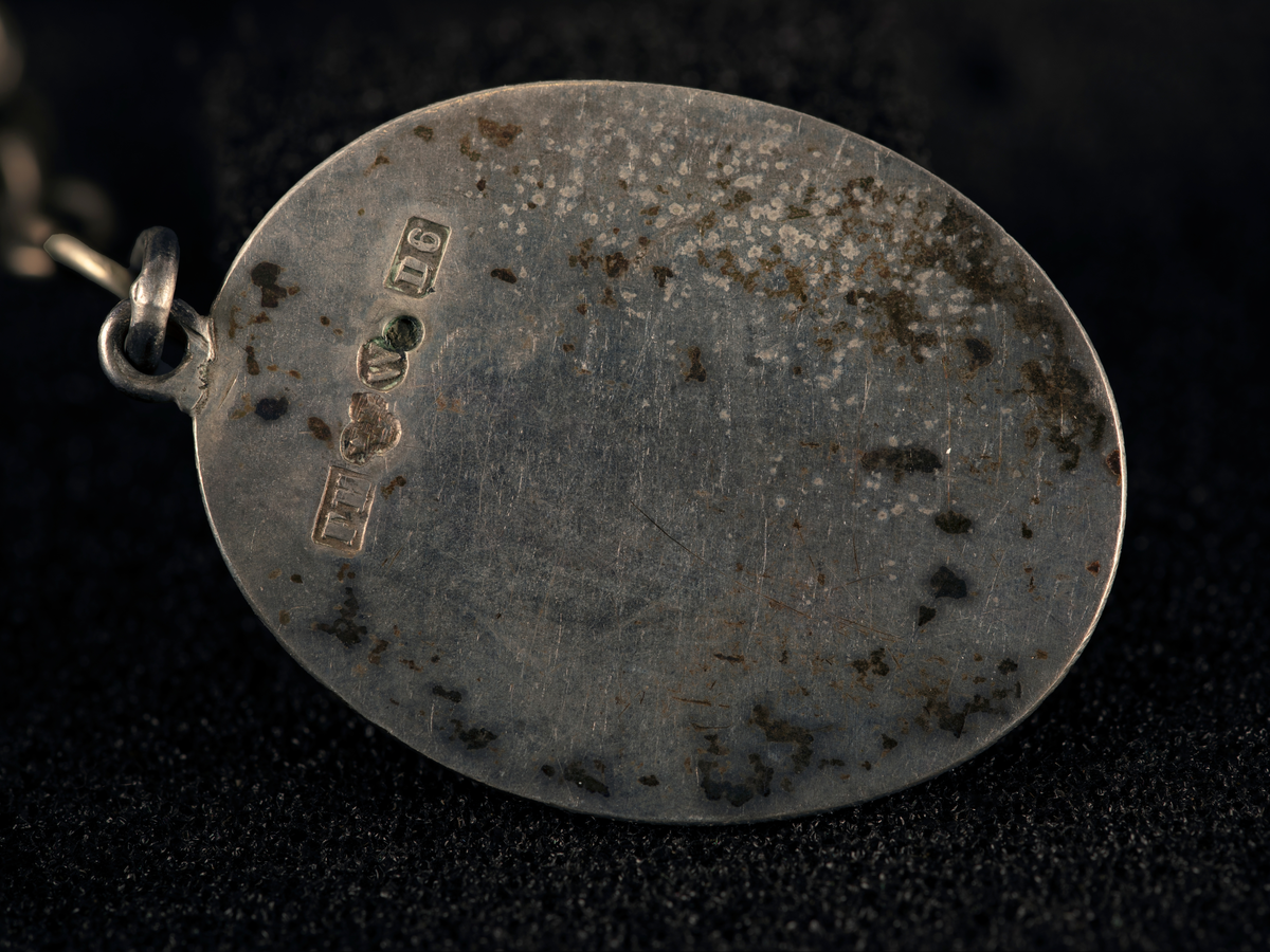 Lommeur med kjede av fire lenker og fem kjeder med anheng. Kjede med signet W, en oval medaljong med to kryssede fakler (WFA), en tannpirker formet som nøkkel, en mynt (F III 1666), firkantet uropptrekker. Stempel: se foto.