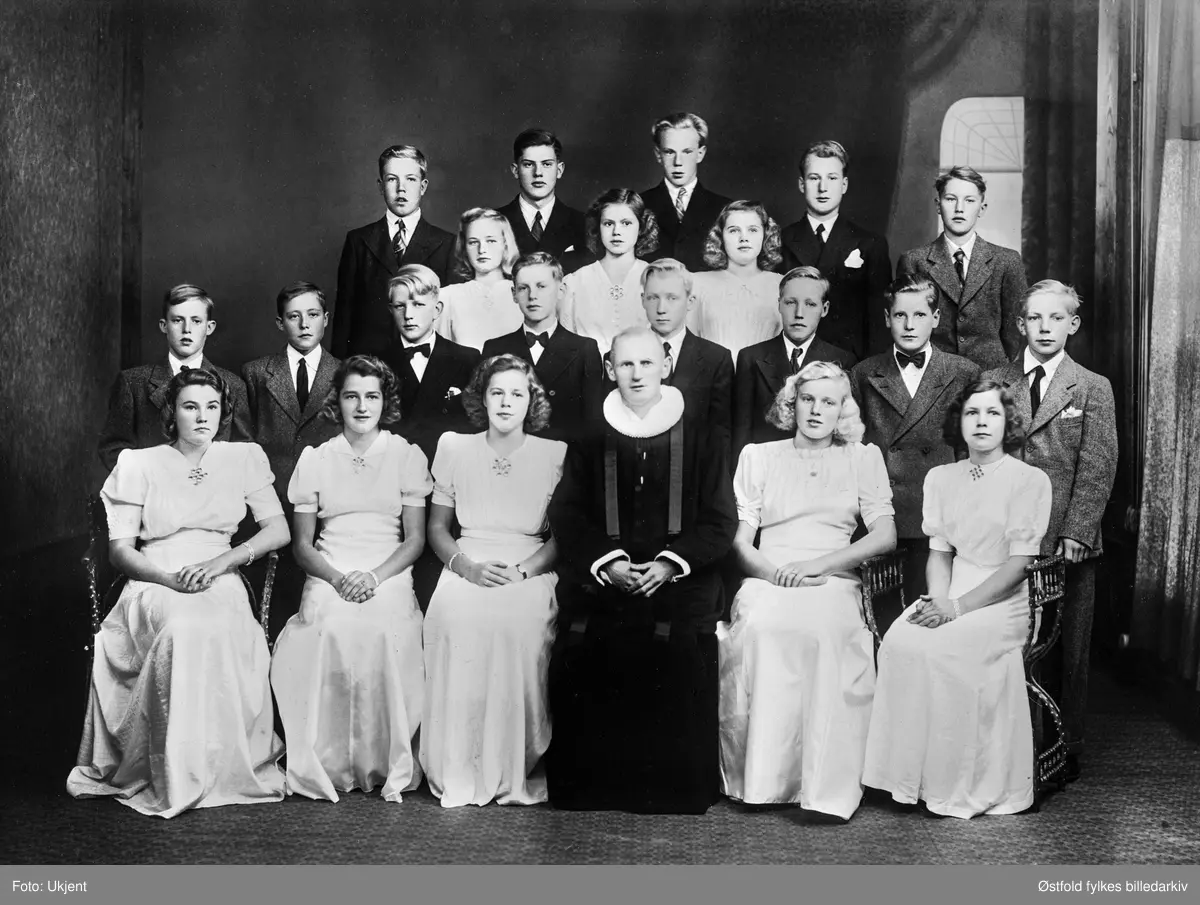 Konfirmanter i Varteig 30. september 1945 med sogneprest Trygve Lavik.
Første rad fra venstrer: Ragnhild Hassel, Astrid Skalle, Bjørg Basken, sogneprest Trygve Lavik, Ellen Brenne og Åse Haugaard.
Andre rad: Peder Bergerud, Ole Bergerud, Ole Skivdal, Nils Johan Lavik, Torbjørn Brennås, Kjell Lunde, Oddmund Gressløs og Egil Simensen.
Tredje rad: Evelyn Andersen, Rakel Kullerud og Anna Berg.
Fjerde rad: : Harry Hansen, Olav Kjærland, Kristen Bergby, Odd Magne Johansen og Kåre Kokkim.
