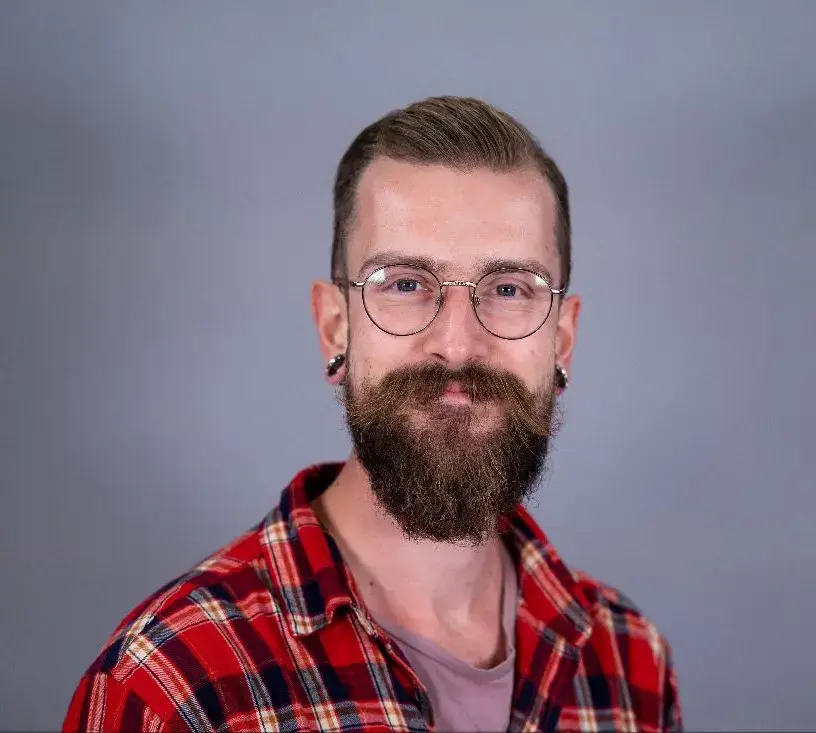 Portrettfoto av Sondre Johan Chesney Kvamme med raudrutetet flanellskjorte