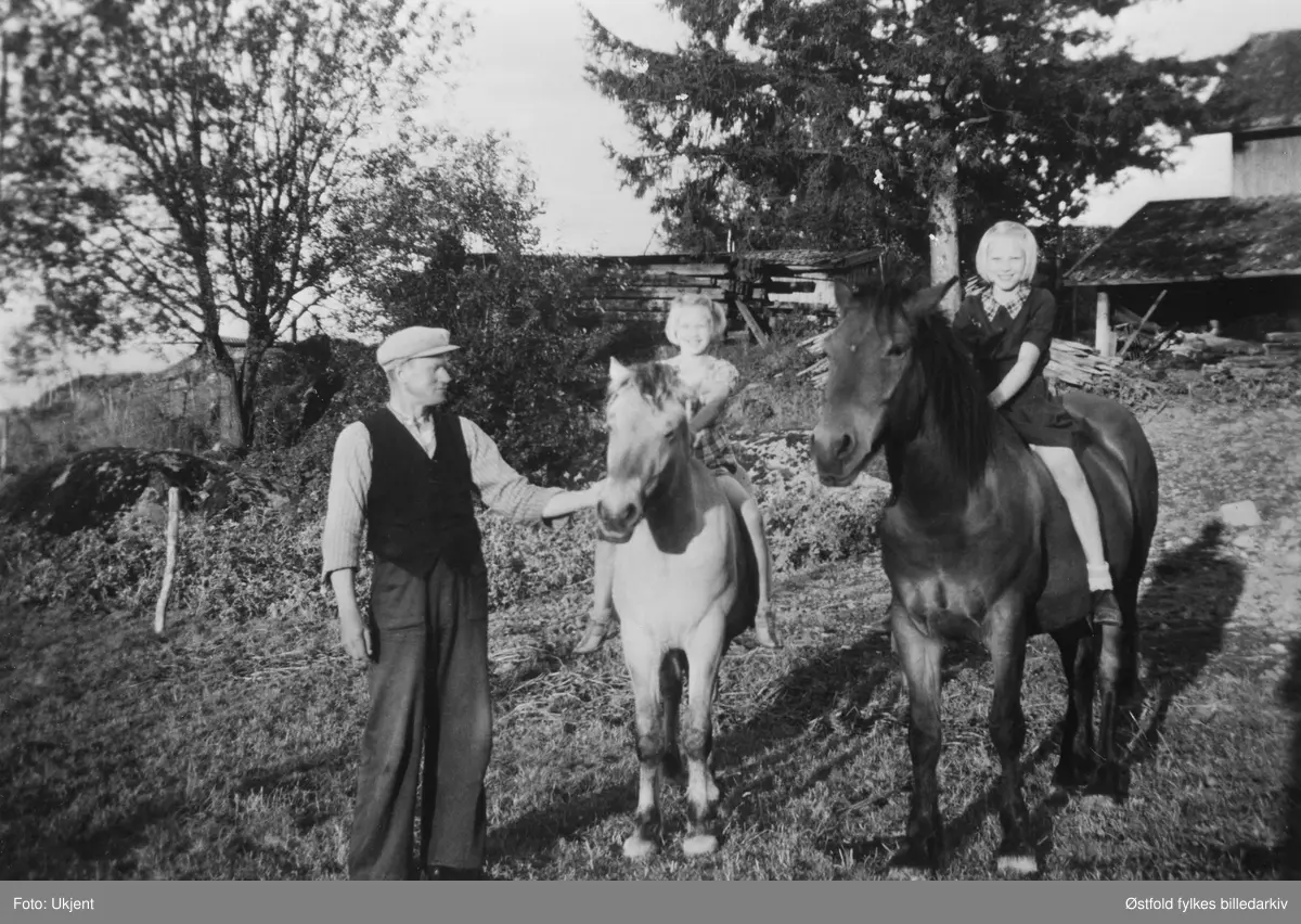 Arnt Lunde med døtrene Ruth og Berit på gården Lunde i Varteig, ca. 1940. Ruth på hesten "Nussen", og Berit på hesten "Trygg".