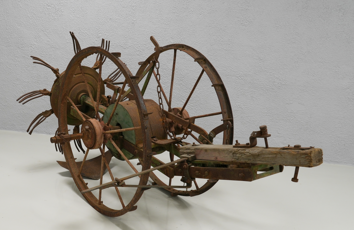 Potetopptakar. Konstruksjonen er nesten heilt laga av metall. Treelementa inkluderer ein sylinder midt på aksen mellom to store hjul og ein bjelke foran. Bak nede er det montert ei stor hakke, og rett ovanfor, litt bak, er kastehjulet. Kastehjulet har ti roterande gafflar, og det er festa til aksen mellom hjula på ein lang metall-sylinder. Hjula og bjelken foran var måla raud, elementa mellom dei var måla i intens grøn farge. På nokre stadar under den grøne farga, er også blå farga synleg. Kastehjulsopptakar var moglegvis for to hestar (?).