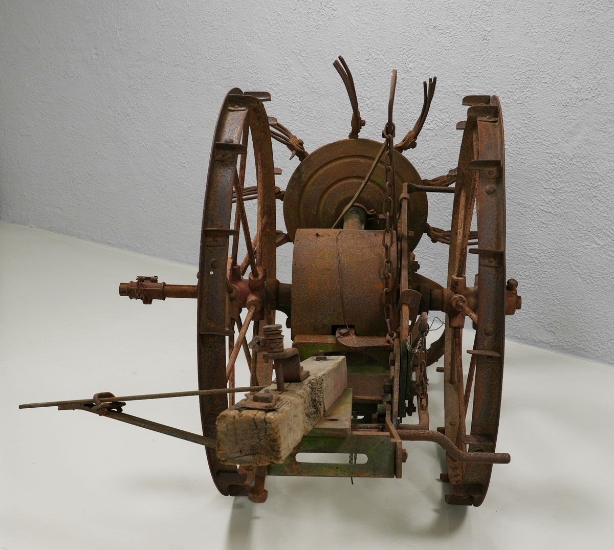 Potetopptakar. Konstruksjonen er nesten heilt laga av metall. Treelementa inkluderer ein sylinder midt på aksen mellom to store hjul og ein bjelke foran. Bak nede er det montert ei stor hakke, og rett ovanfor, litt bak, er kastehjulet. Kastehjulet har ti roterande gafflar, og det er festa til aksen mellom hjula på ein lang metall-sylinder. Hjula og bjelken foran var måla raud, elementa mellom dei var måla i intens grøn farge. På nokre stadar under den grøne farga, er også blå farga synleg. Kastehjulsopptakar var moglegvis for to hestar (?).