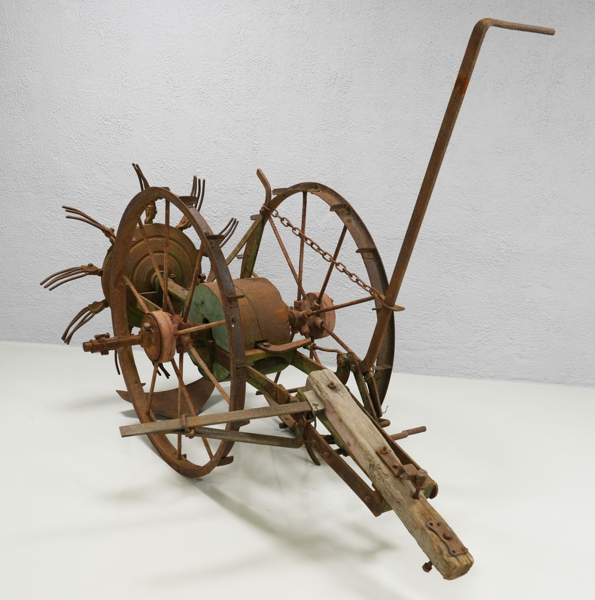 Potetopptakar. Konstruksjonen er nesten heilt laga av metall. Treelementa inkluderer ein sylinder midt på aksen mellom to store hjul og ein bjelke foran. Bak nede er det montert ei stor hakke, og rett ovanfor, litt bak, er kastehjulet. Kastehjulet har ti roterande gafflar, og det er festa til aksen mellom hjula på ein lang metall-sylinder. Hjula og bjelken foran var måla raud, elementa mellom dei var måla i intens grøn farge. På nokre stadar under den grøne farga, er også blå farga synleg. Kastehjulsopptakar var moglegvis for to hestar (?).