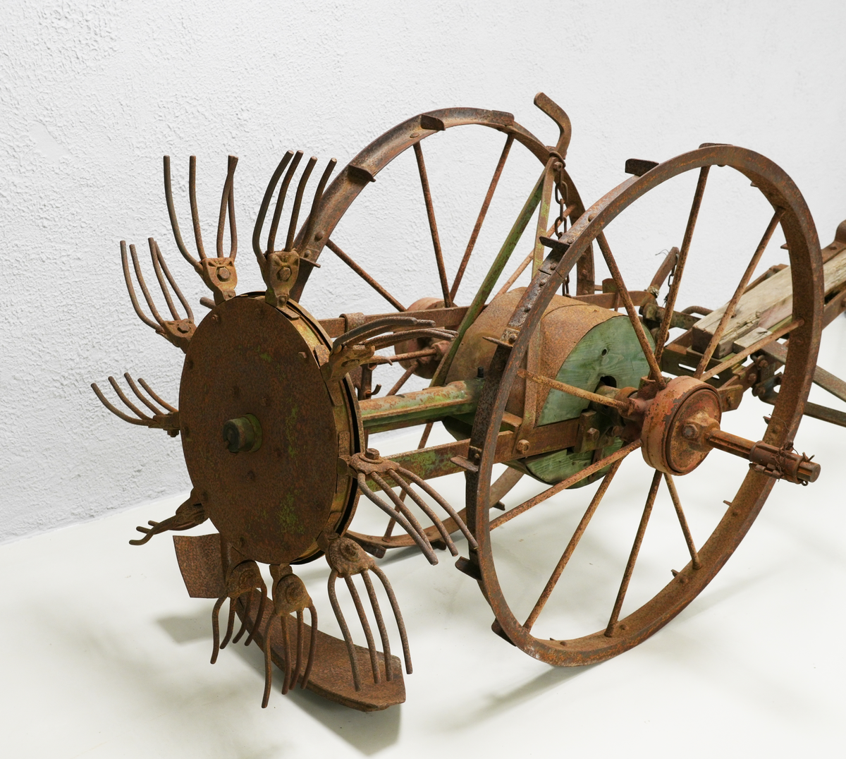 Potetopptakar. Konstruksjonen er nesten heilt laga av metall. Treelementa inkluderer ein sylinder midt på aksen mellom to store hjul og ein bjelke foran. Bak nede er det montert ei stor hakke, og rett ovanfor, litt bak, er kastehjulet. Kastehjulet har ti roterande gafflar, og det er festa til aksen mellom hjula på ein lang metall-sylinder. Hjula og bjelken foran var måla raud, elementa mellom dei var måla i intens grøn farge. På nokre stadar under den grøne farga, er også blå farga synleg. Kastehjulsopptakar var moglegvis for to hestar (?).