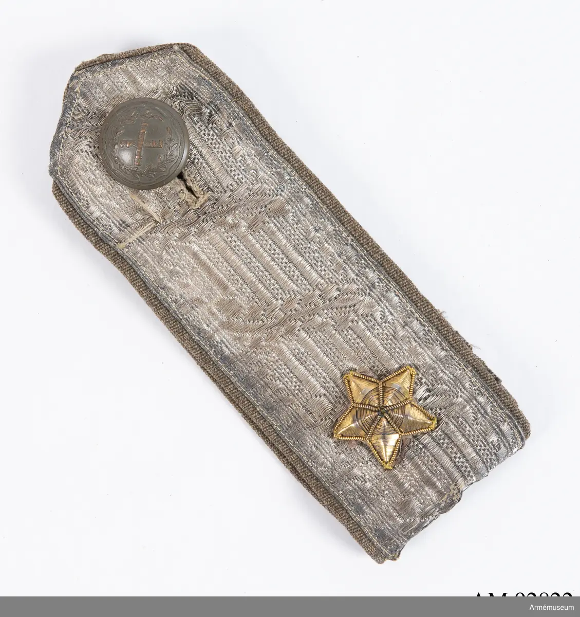 Axelklaff av silverfärgad metallgalon med en stjärna.

Axelklaffen är tillverkad av 4,5 cm bred silvergalon för Generalitetet, monterad på gråbrungrönt ylletyg. Den består av en ca 28 cm lång tygremsa, fodrad med samma tyg, dubbelvikt och med knapp i ena änden och knapphål i den andra. På ovansidan r metallgalonen fastsydd.
Knappen i ena änden är en bronsfärgad knapp för Generalitetet, fastsatt med en brungrön melerad knapp på baksidan, fäst genom ett mindre knapphål. Axelklaffen pryds av en stjärna, utförd i metallbroderi med platt metall-lan.