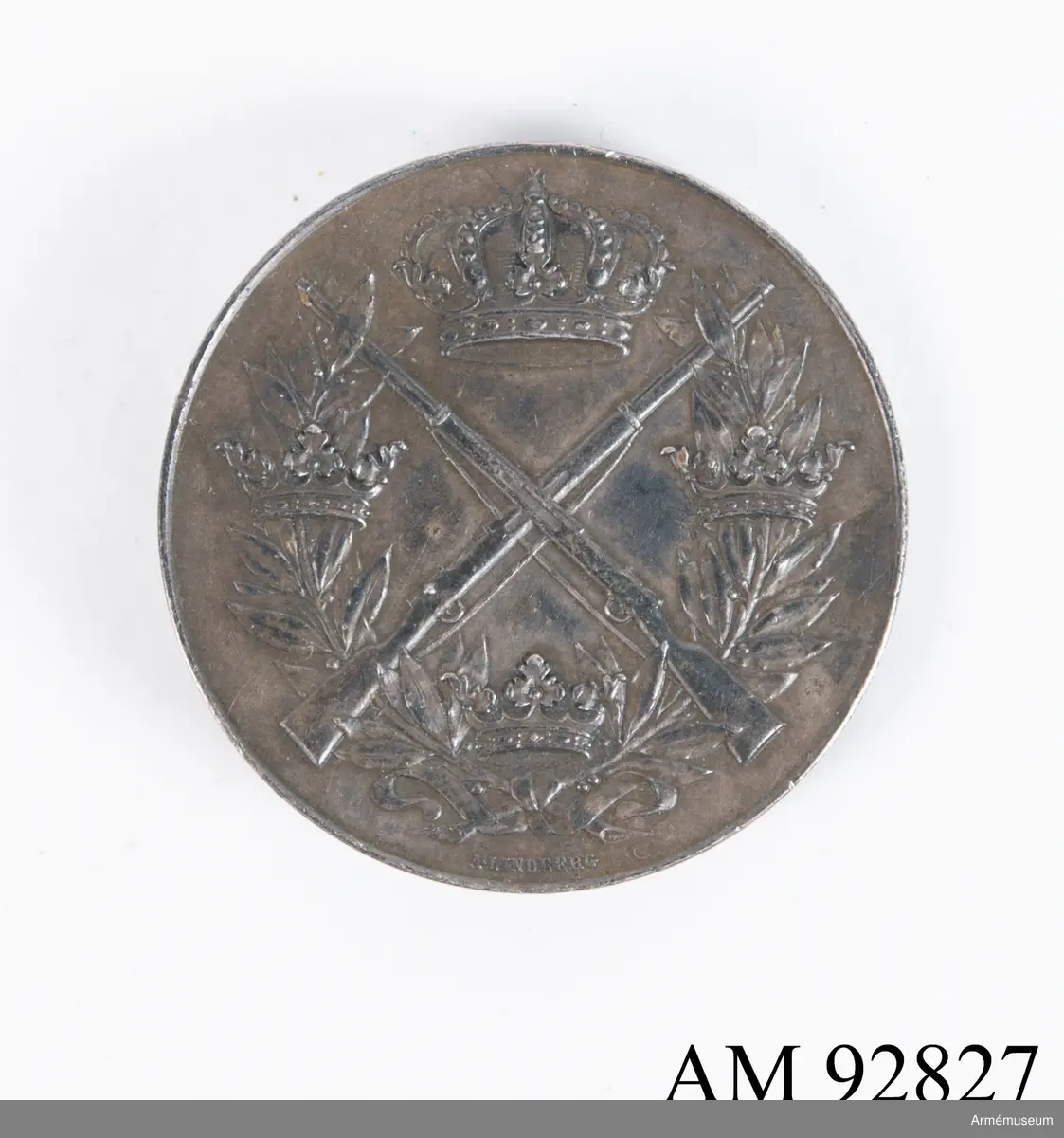 Svenska Arméns skyttemedalj i valören silver.

Medaljen är gjord av svartnad silver, och pryds på framsidan av en relief med lagerkrans som trätts igenom tre mindre kronor, under två korslagda gevär under en större kunglig krona.
På frånsidan en text i relief: "Svenska arméns skyttemedalj vid prisskjutning med eldhandvapen". Medaljen fästes med en fastlödd nål på baksidan.
Längs med kanten står det graverat: "Silver 1918".