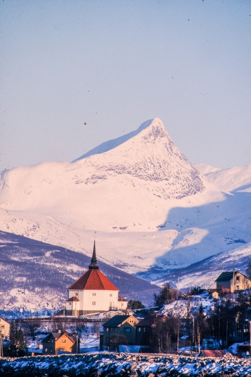 Ankenes kirke med Vomtind i bakgrunnen.  Foto fra moloen på Ankenes. Foto: Harald Harnang.