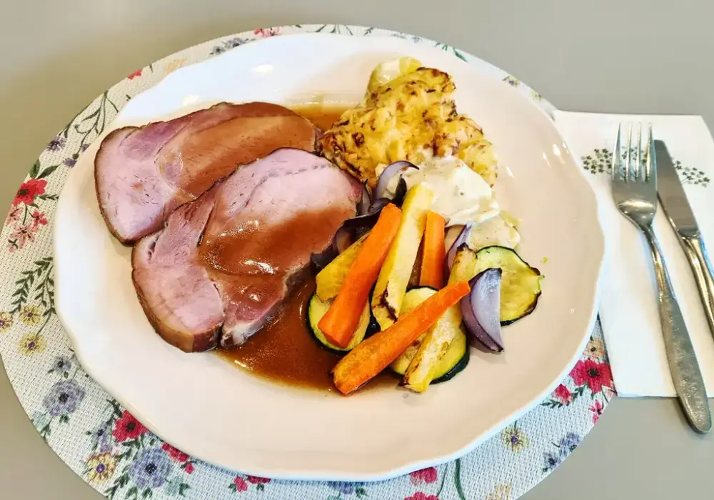 Tallerken med kjøtt i saus, ovnsbakte grønnsaker og potetgrateng.