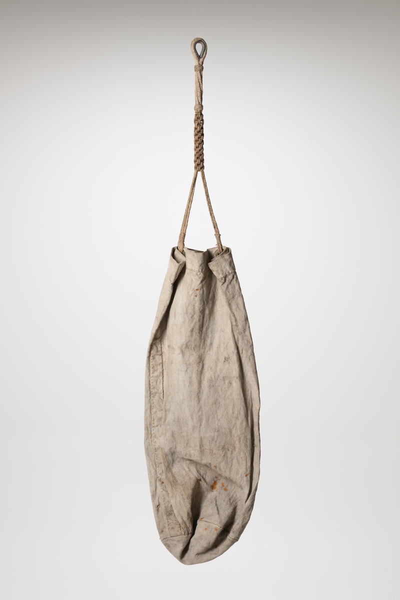En dittybag er en liten bag eller pose  som spesielt ble brukt av sjømenn til frakt og oppbevaring av småting som sysaker, toalettsaker, etc. Pose i stoff med håndtak og dekor. To metallringer festet øverst i posen til å feste håndtaket i. Håndtak laget av tau. Tauet flettet i ulike flettverk. Tauet er festet rundt en kause. Dekor påmalt. To norske flagg over en rød sirkel med hvit kant rundt. En blomst malt på i den røde sirkelen. To grønne, to blå og to hvite blader. Under sirkelen er det malt initialene .K.O. Under et grønt blad som kan ligne på blad fra rognetre.
