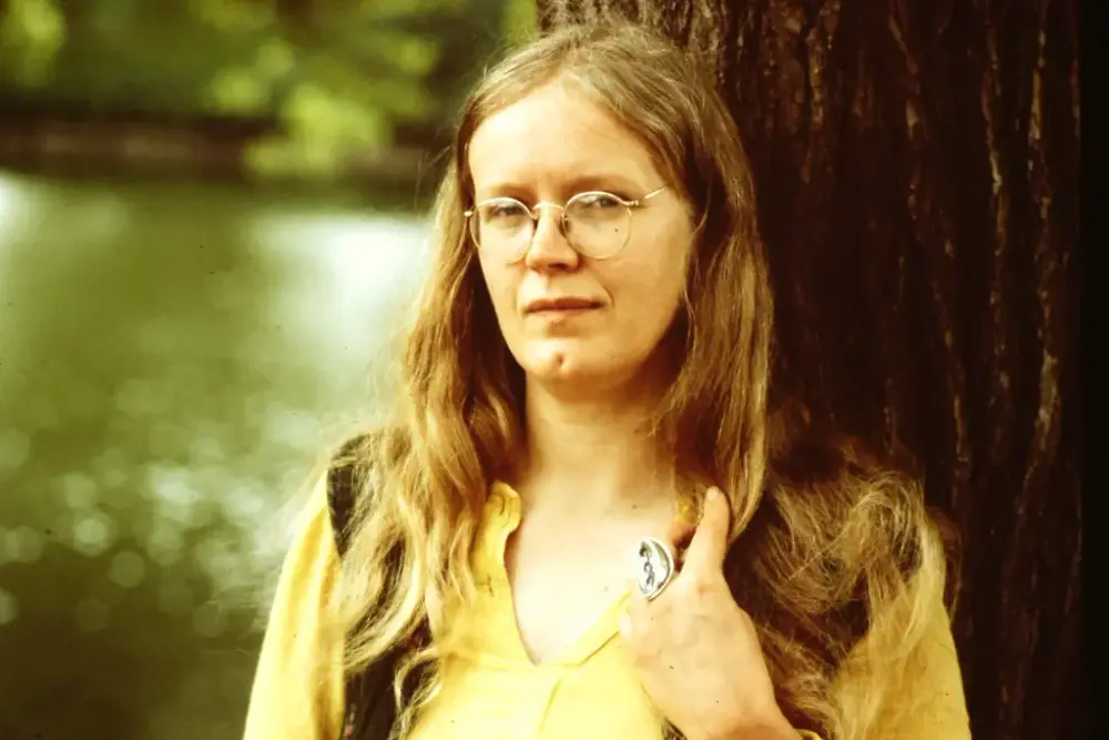 Porträtt av konstnären Monica Sjöö, med runda glasögon hår.