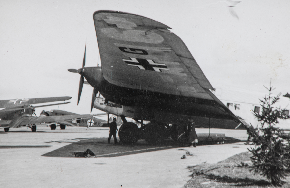 Ukjent sted, andre verdenskrig, flyplass med tysk fly, "von Hindenburg". Til venstre to tremotors Junkers Ju 52 transportfly.