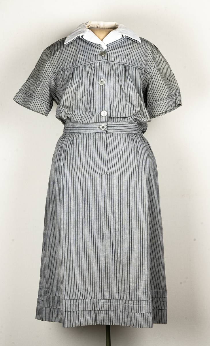 Hemsysteruniform med tillbehör.