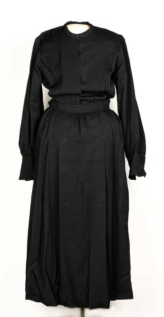 Hemsysteruniform med tillbehör.