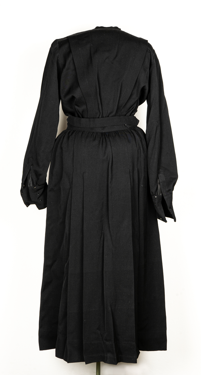Hemsysteruniform med tillbehör.
