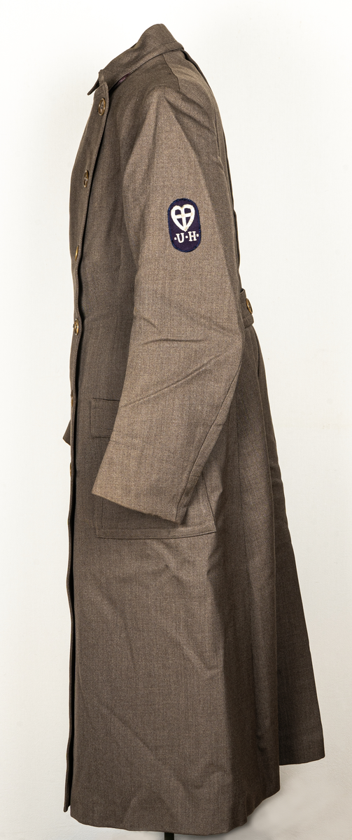 Hemsysteruniform med tillbehör.