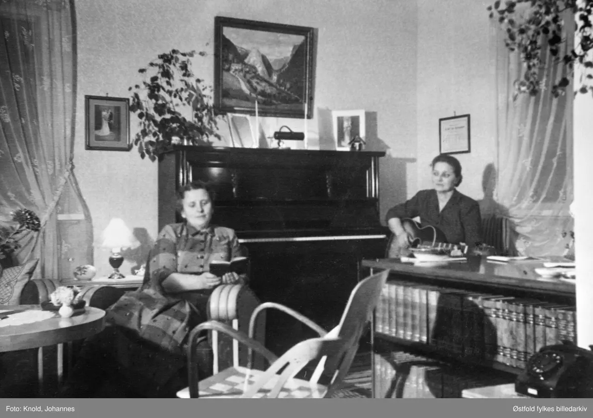 Sangstund i Varteiggata, Sarpsborg 1955.
Gudrun Lagerta Knold og Synnøve Hovland i stuen med gitar og salme eller sangbok.
Varteiggata er idag St. Nikolas gate.