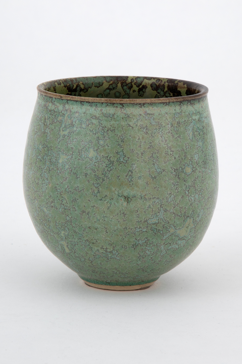 Vase med lav og rundt begerform. Utvendig blek, gulgrønn glasur. Innvendig olivengrøn med brungrå flekker. Gulhvitt gods.